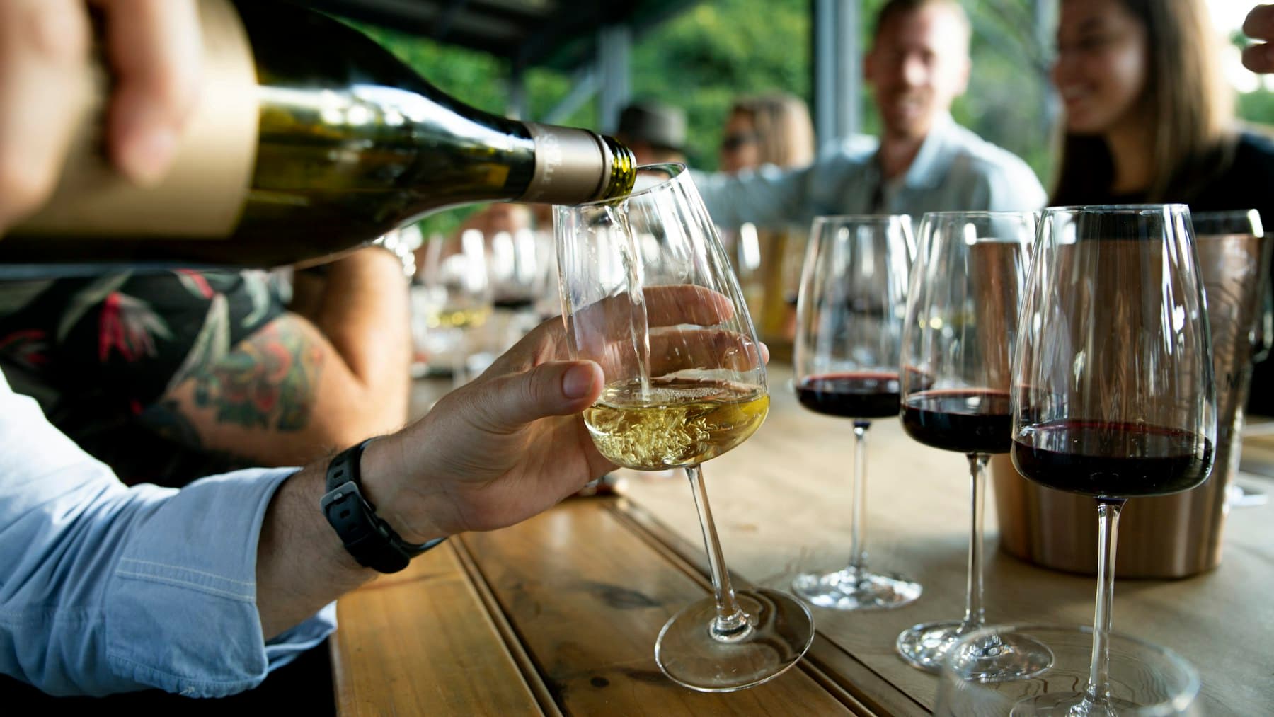 A sommelier pours wine for a seated group during a guided tasting.