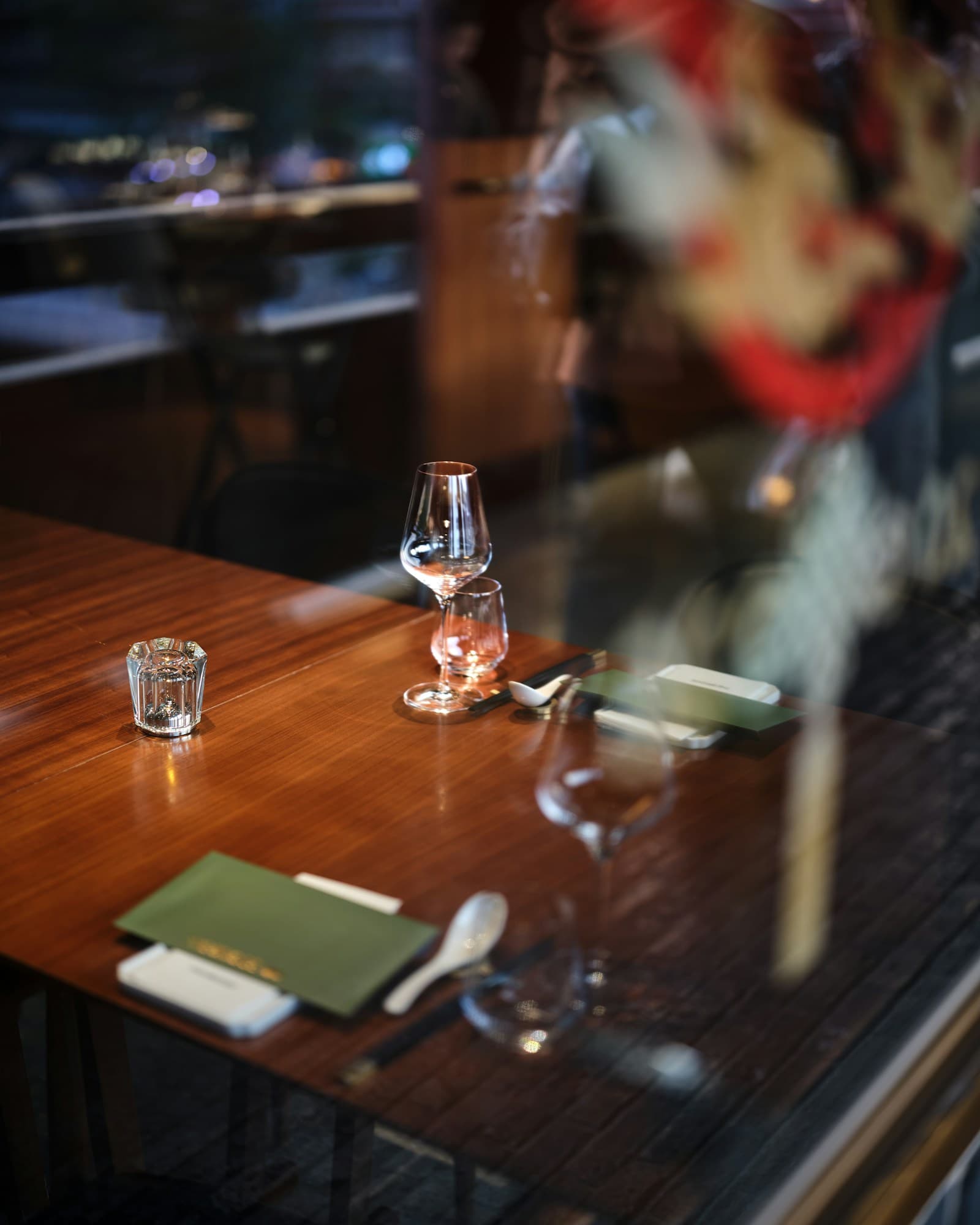 Warmly lit table set with wine glasses, menus, and cutlery