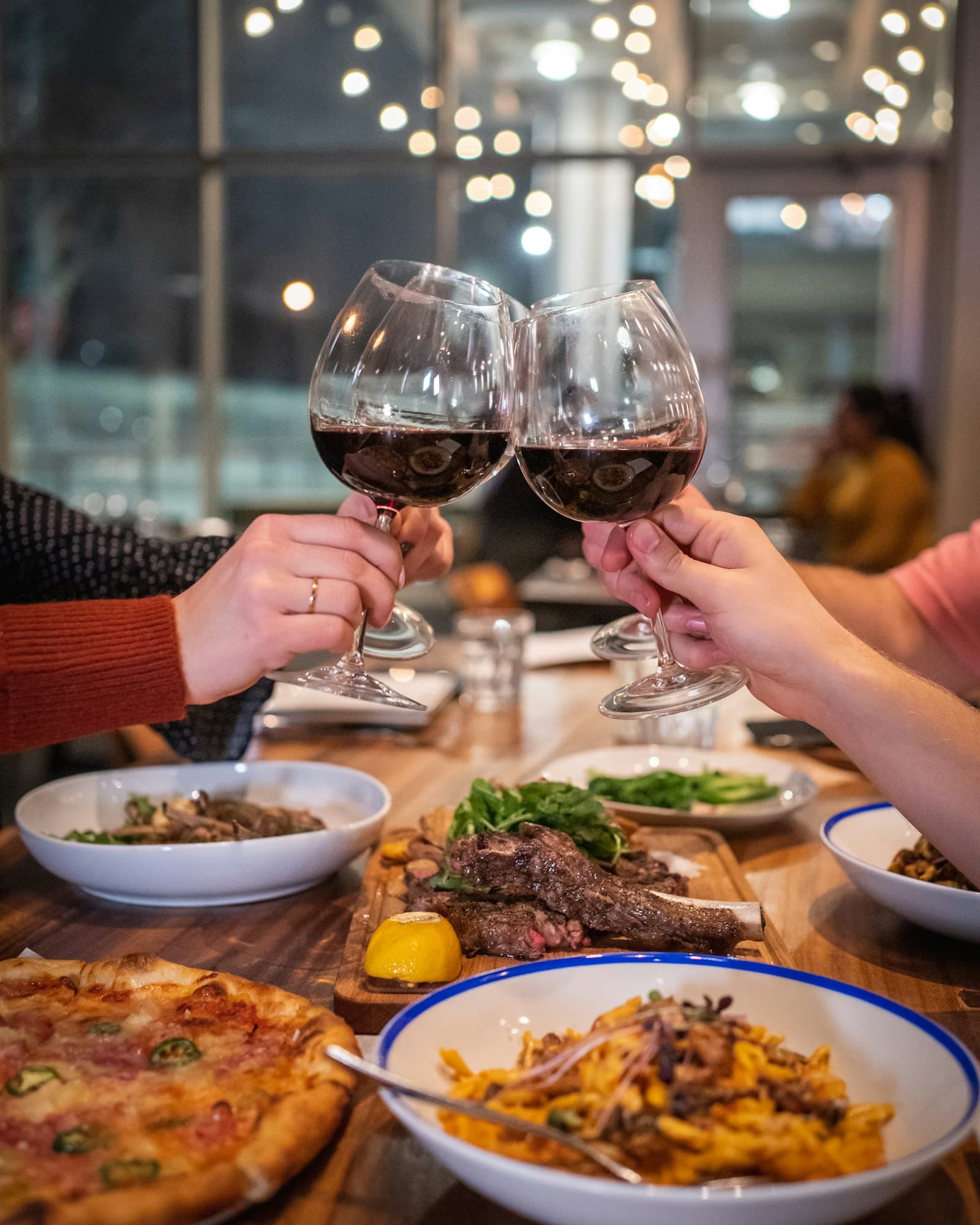 Friends raising glasses over a shared dinner