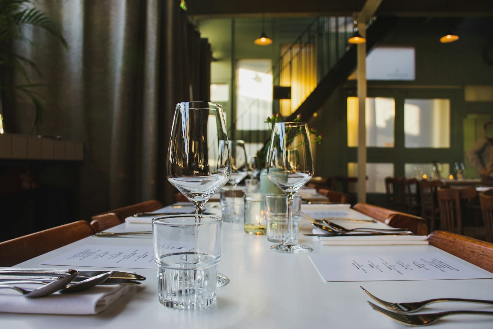 Individual tasting places with wine glasses, water, and printed notes