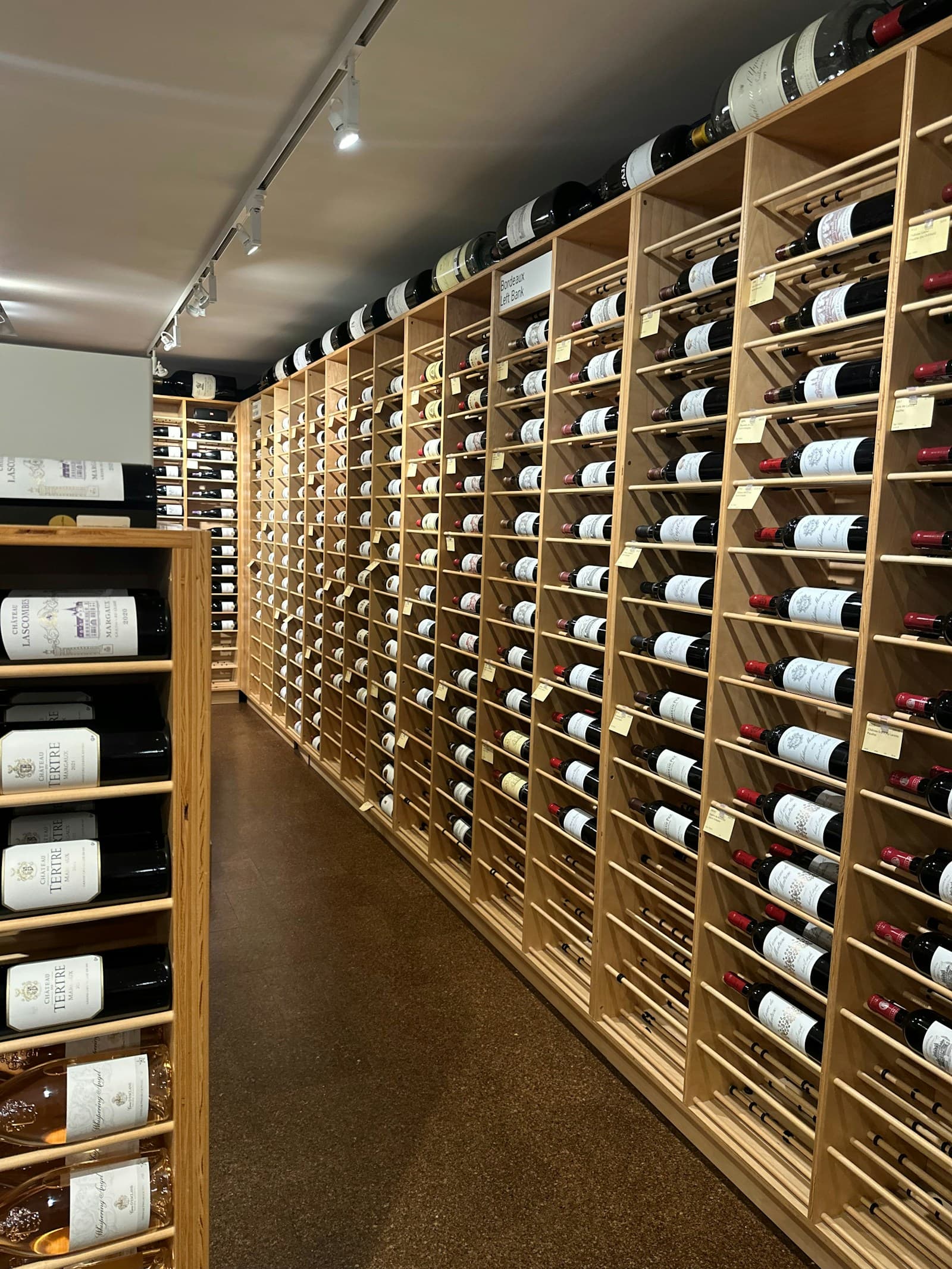 Rows of wine bottles stored horizontally in wooden cellar racks
